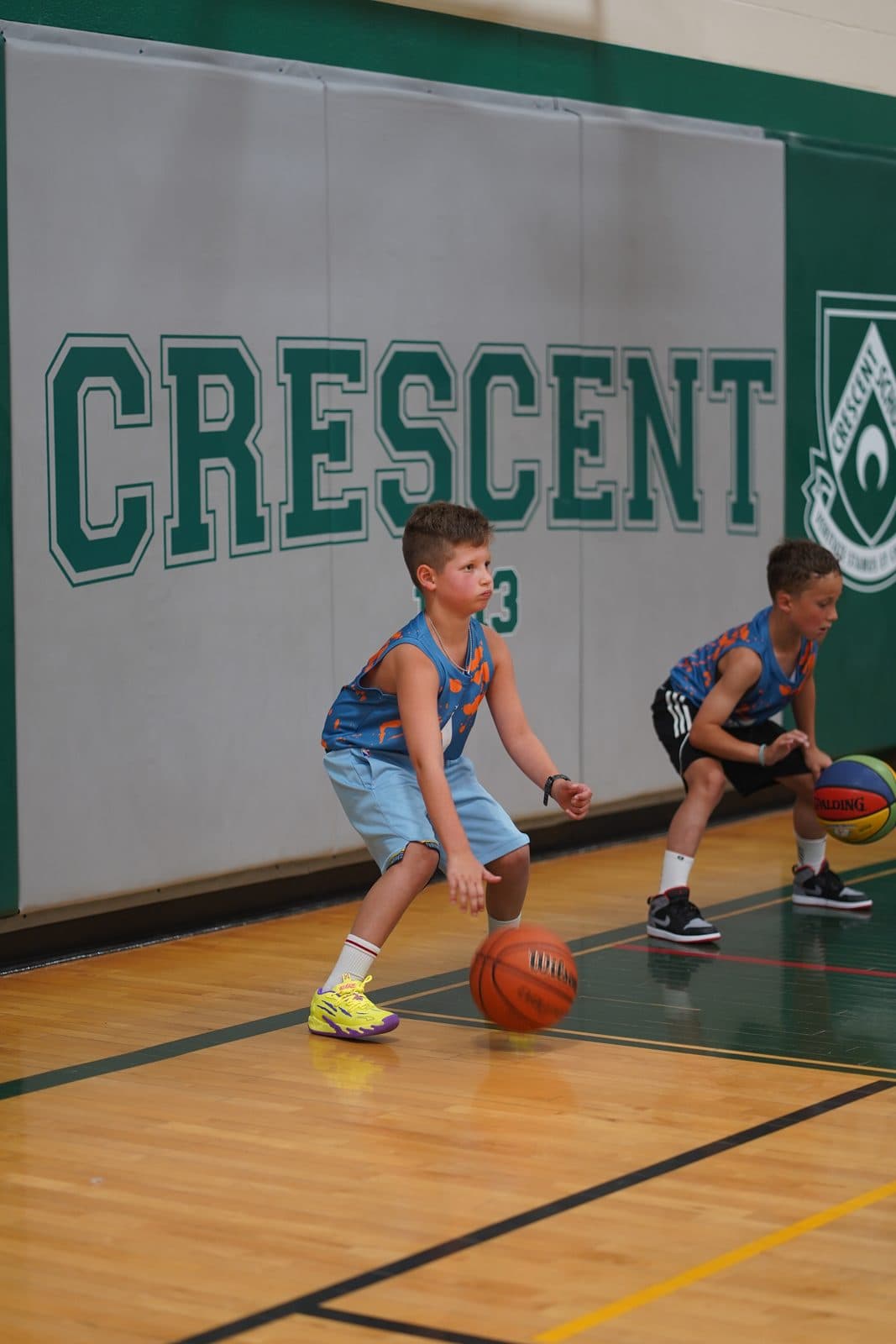 Two young athletes working through a stationary dribbling drill