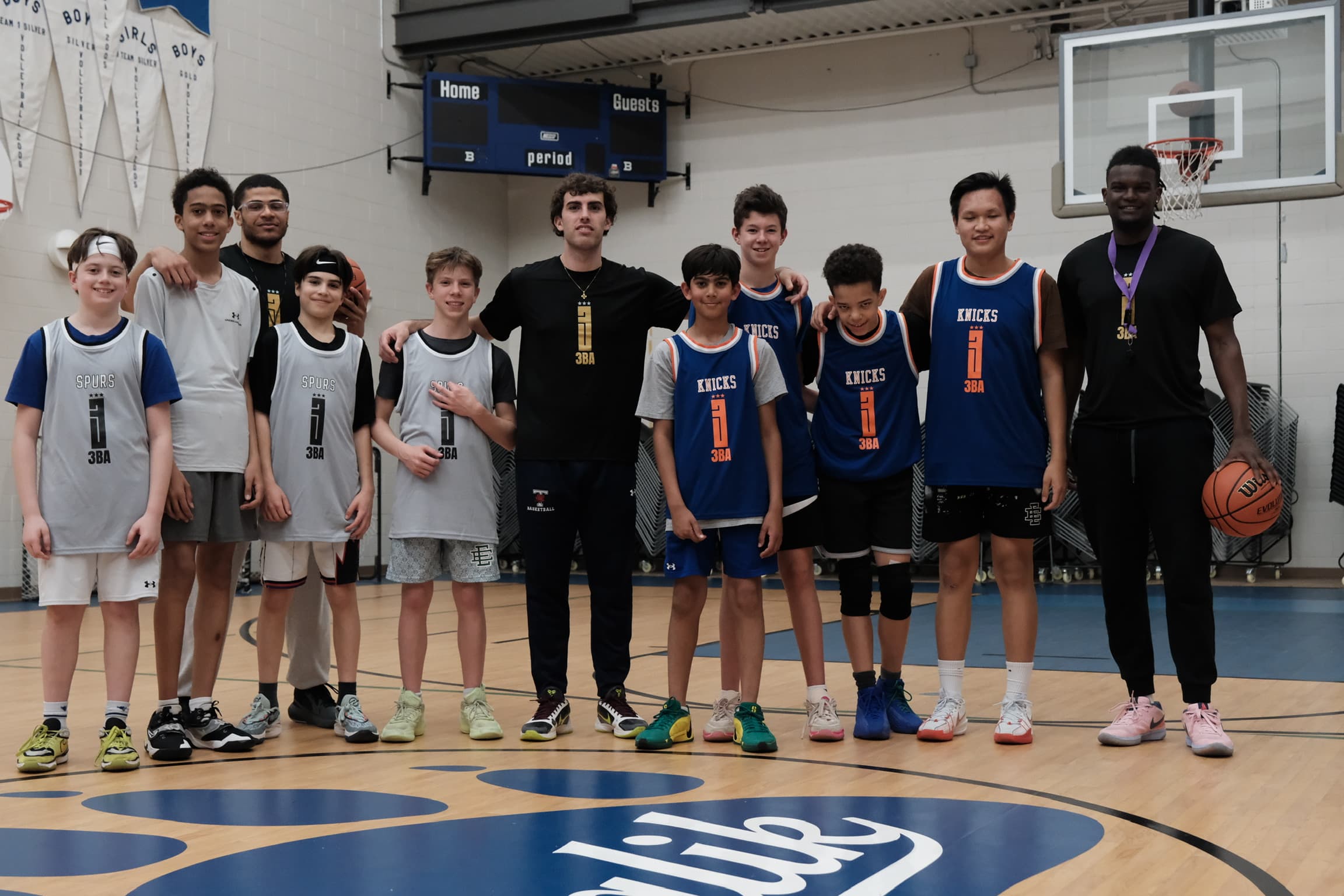A full squad posing together under the scoreboard after a 3BA session