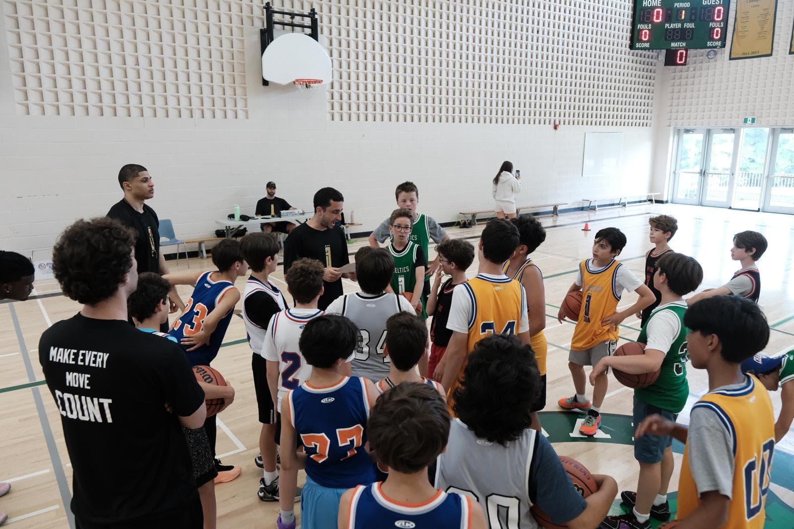 A 3BA coach talking to a huddle of players mid-session