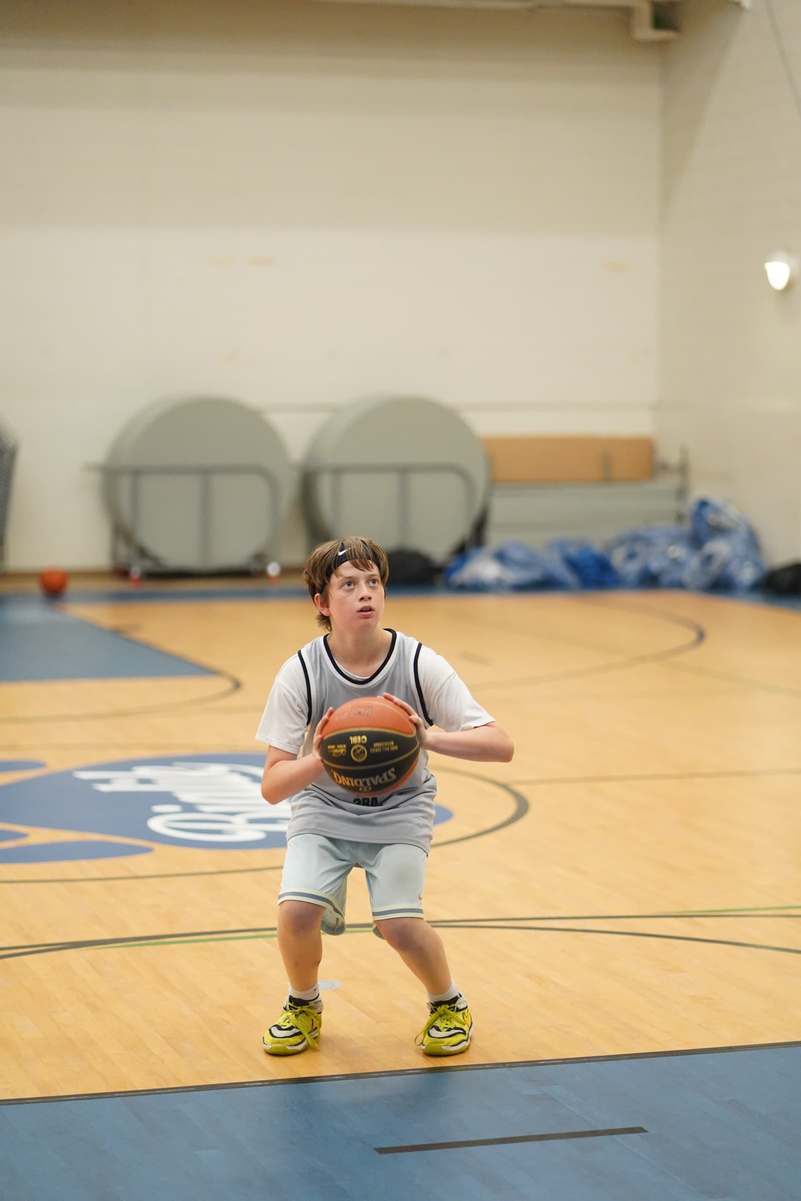 A young athlete working on shooting form, eyes locked on the rim