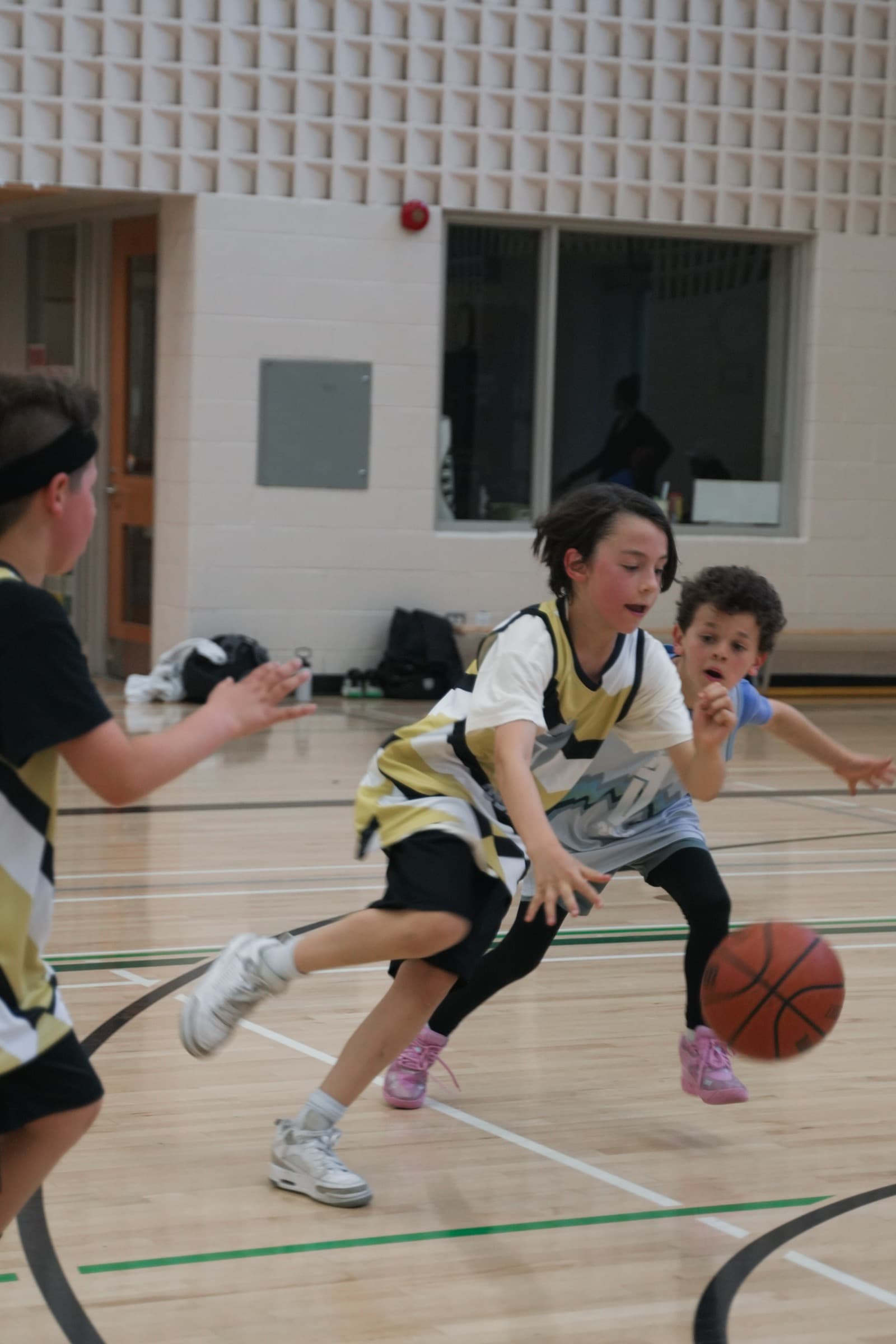 A young player driving hard to the hoop past a defender