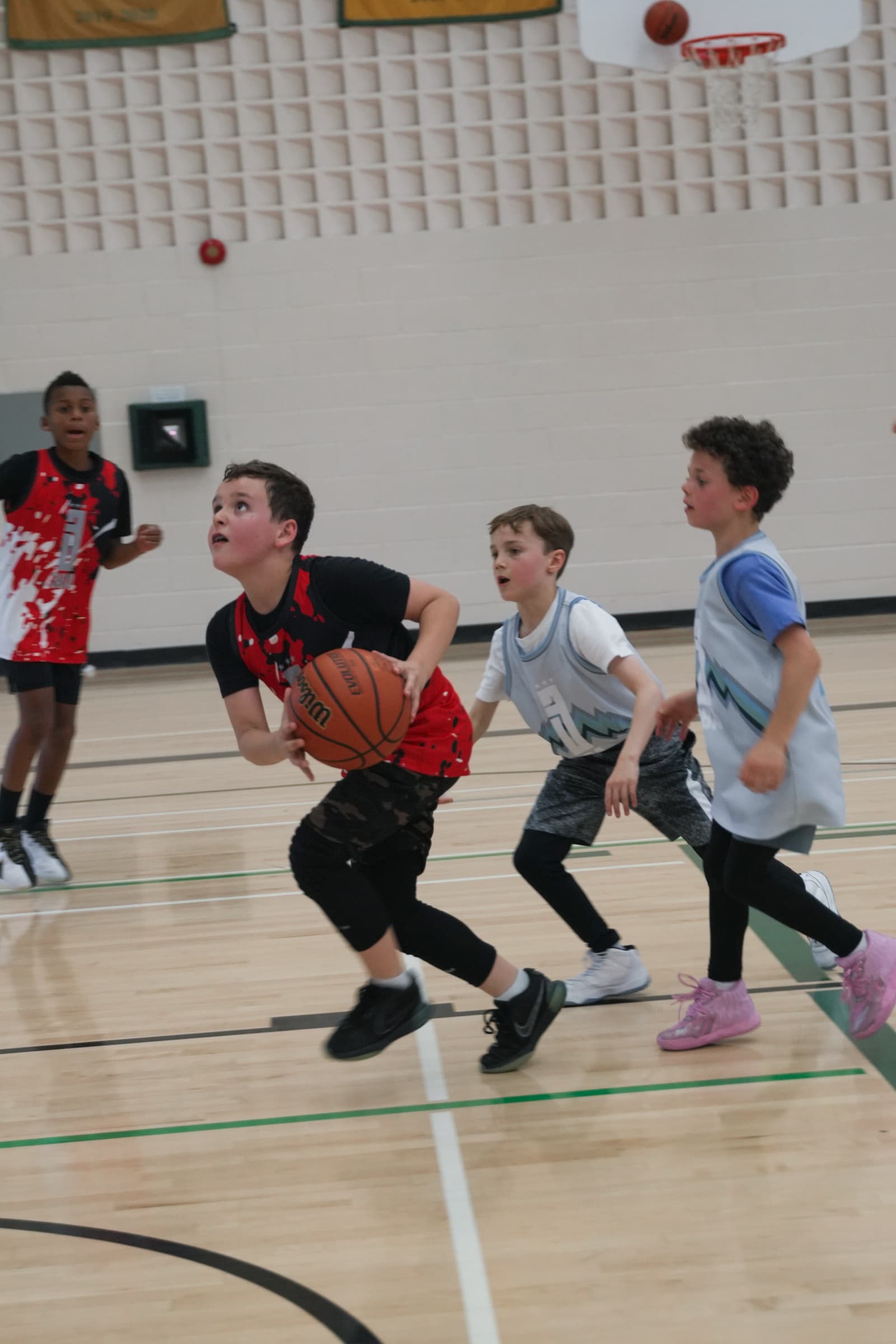 A player rising toward the rim for a layup with defenders trailing