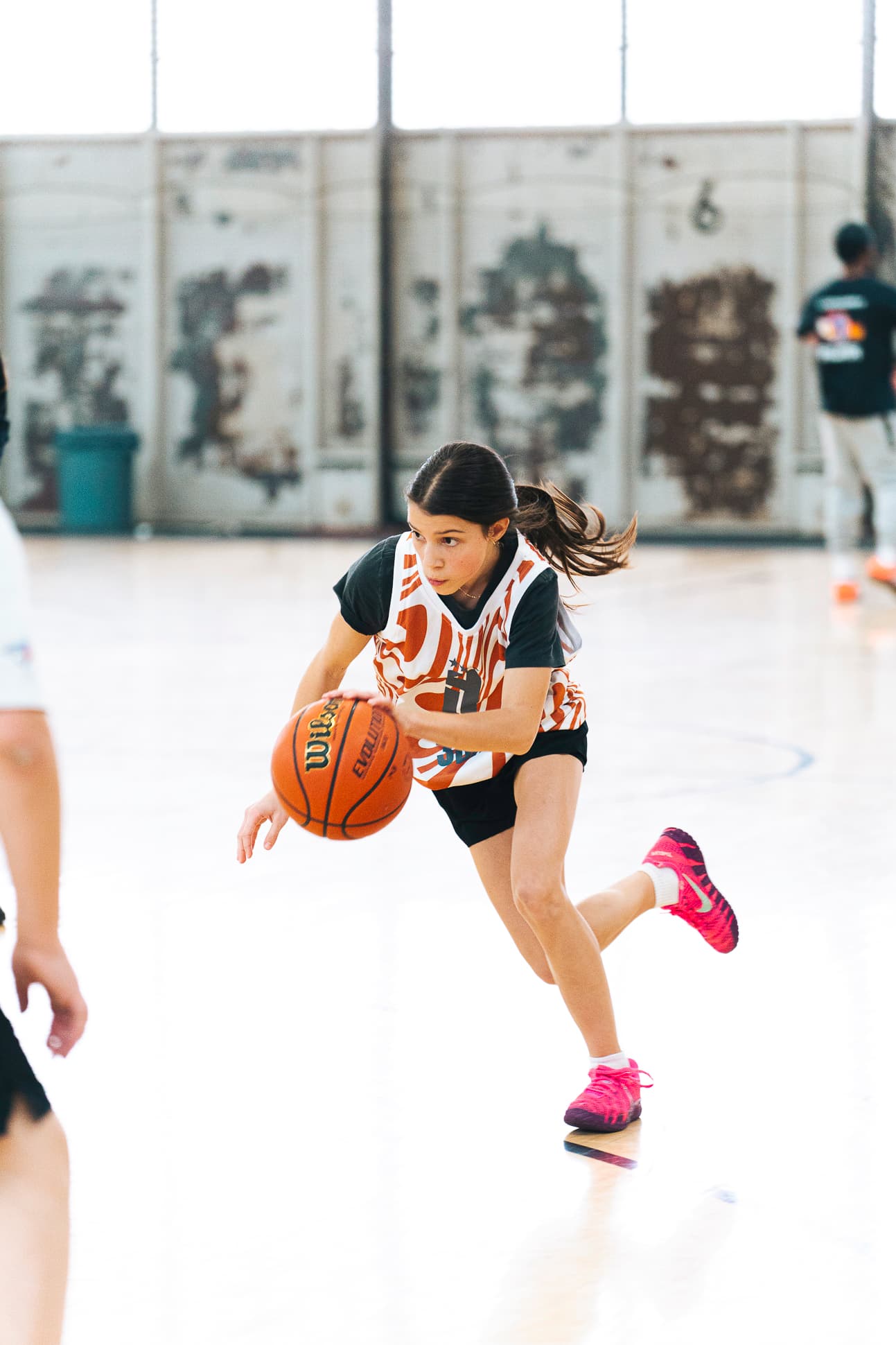 A girl in a 3BA jersey driving the ball up the floor at full speed