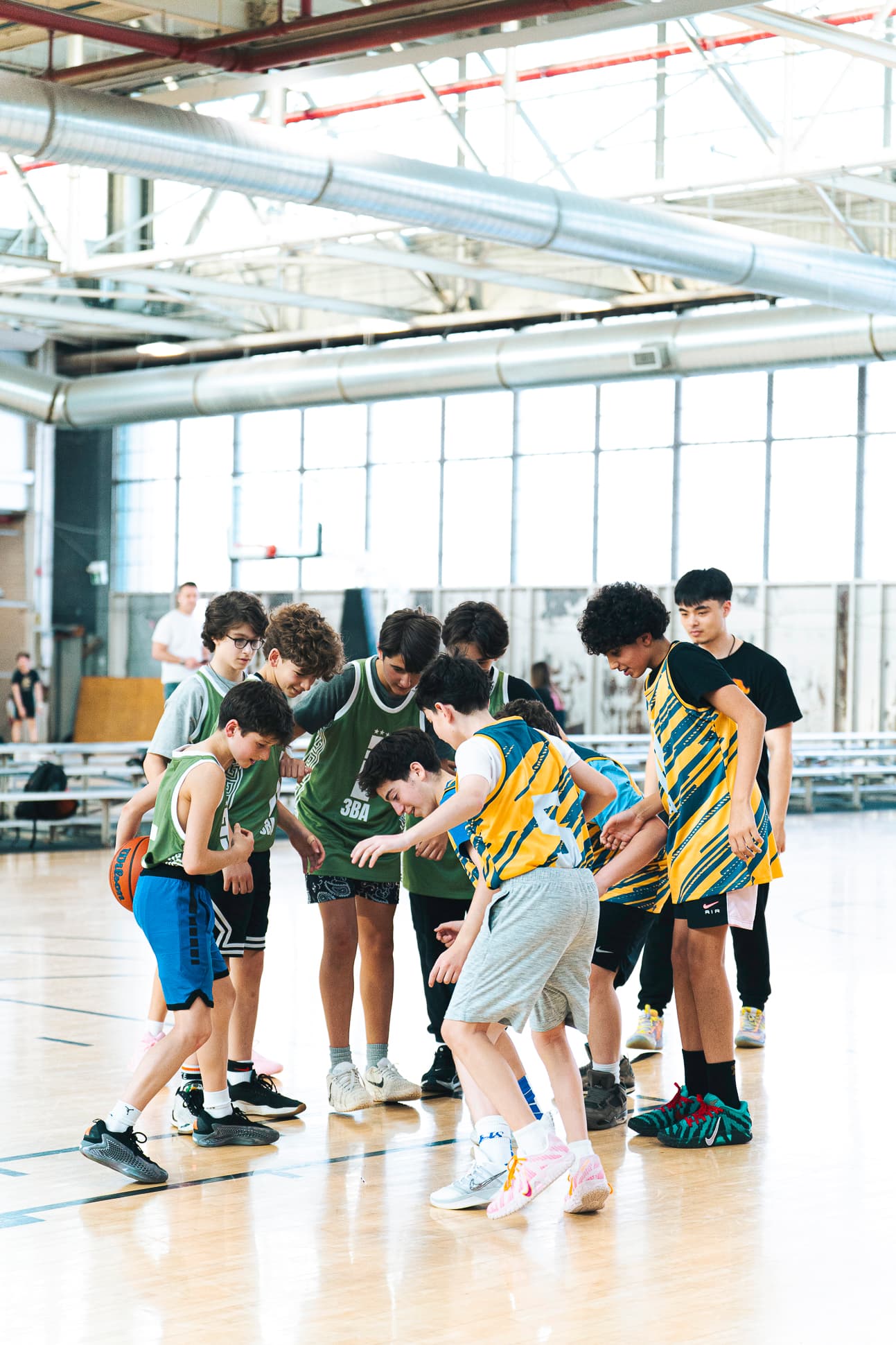 A group of Youth division players packed together battling for a loose ball
